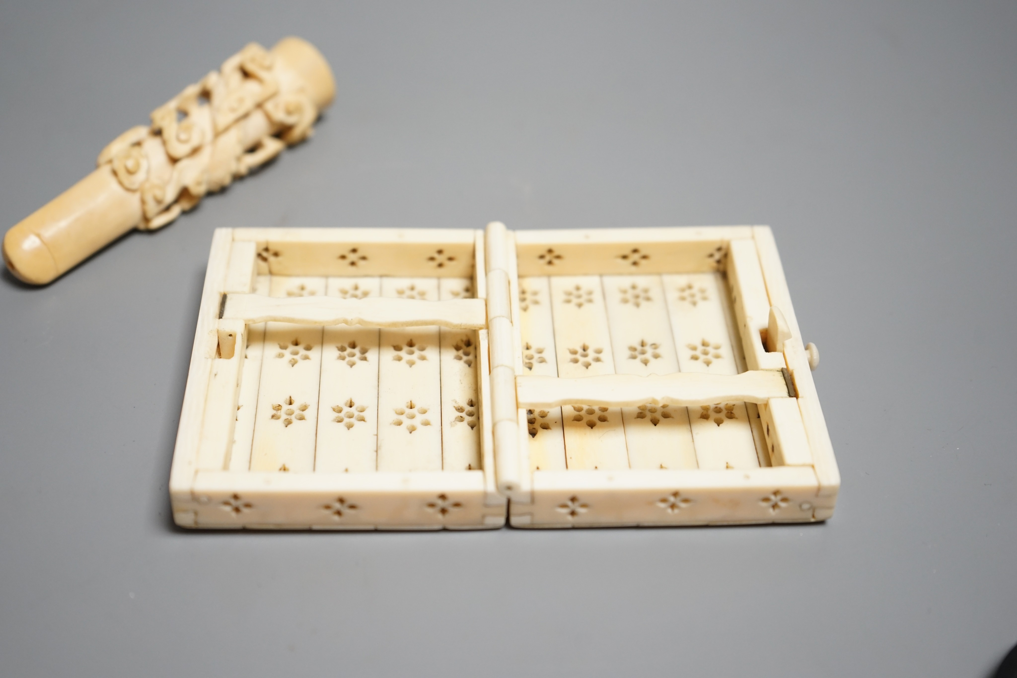 A Chinese ivory cigarette case, 8 x 6cm, and a Chinese carved ivory cheroot holder